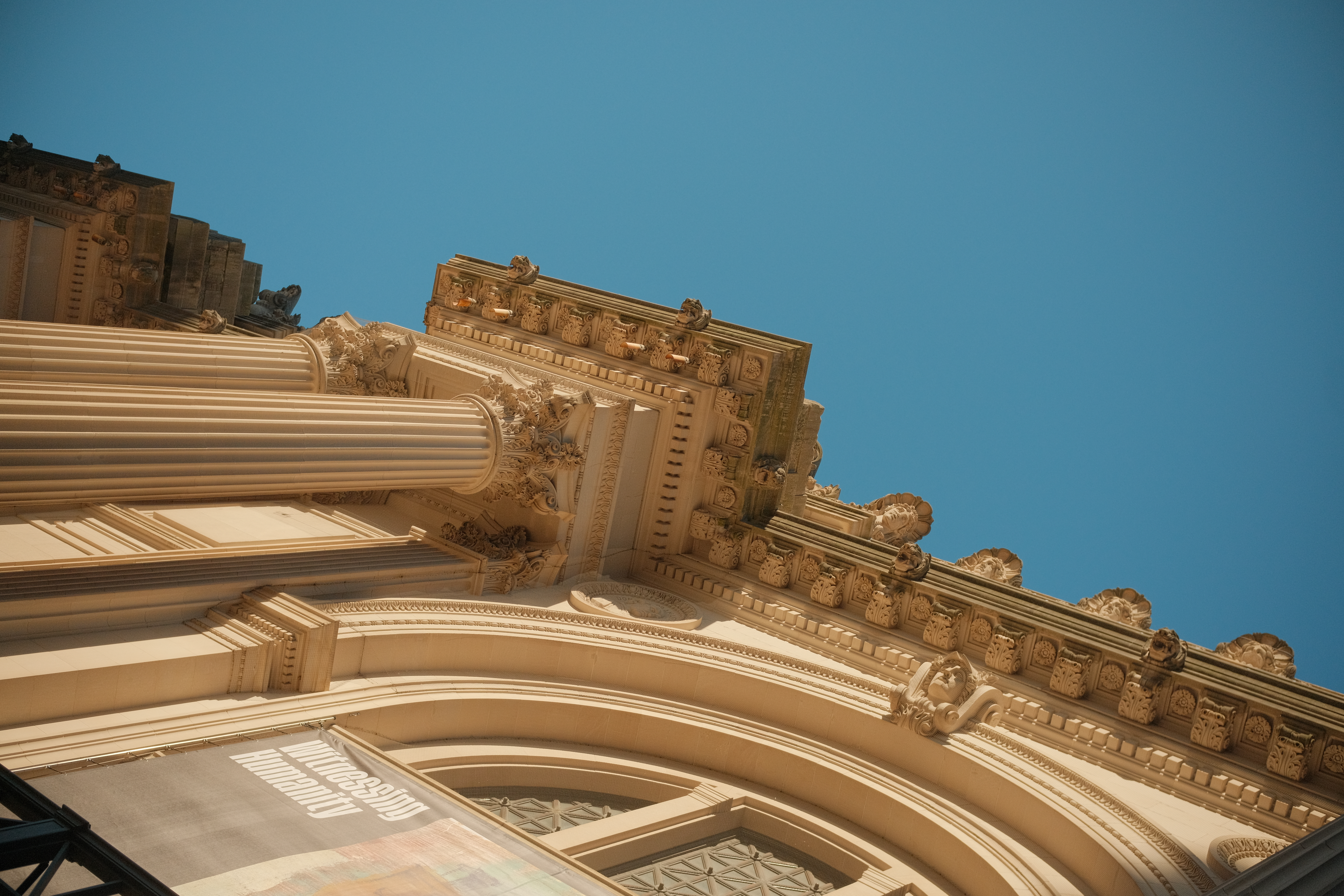 A picture of the Met Museum focusing on the pillars against a clear sky